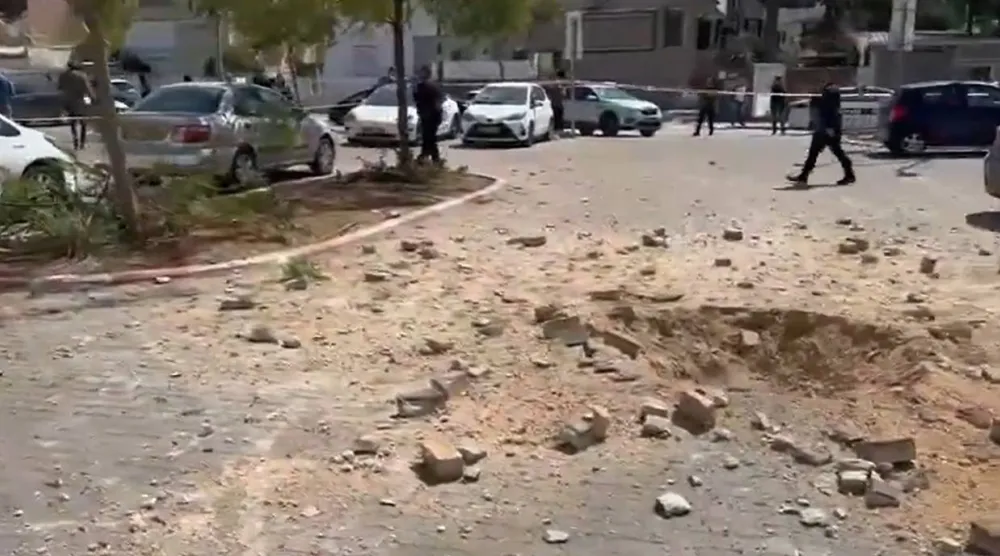 صورة مثبتة من مقطع فيديو نشرته وسائل إعلام عبرية لحُفر صغيرة ناجمة عن مواقع سقوط الصواريخ الإيرانية وسط إسرائيل