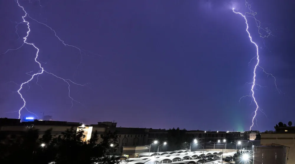 ومضات البرق تتألق في سماء مدينة الكويت (أ.ف.ب)