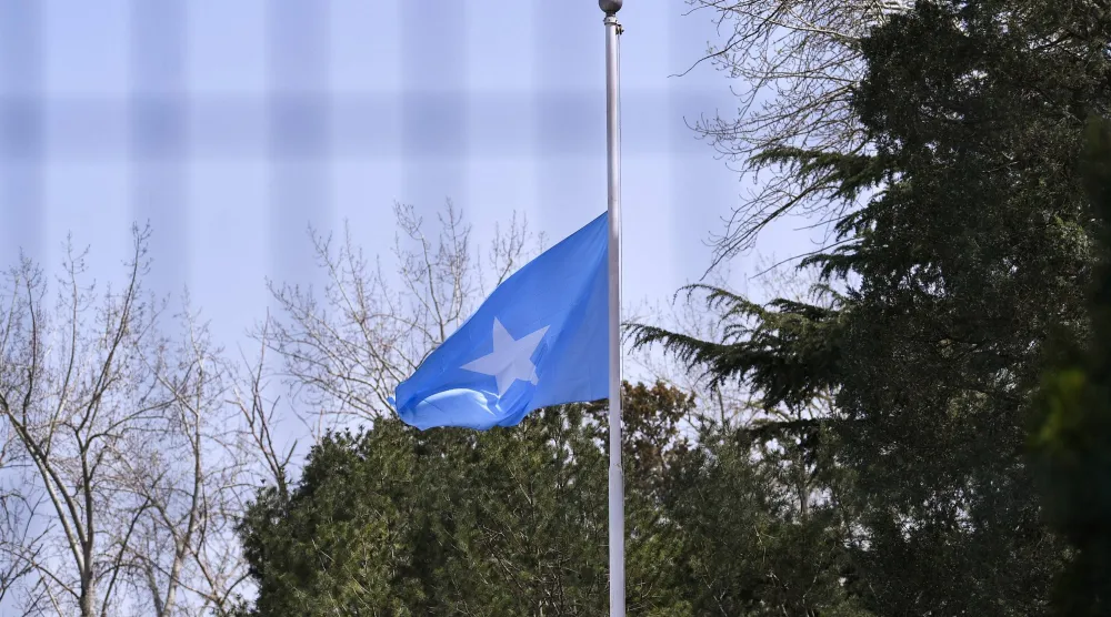 عَلَم الصومال منكساً حداداً على وفيات جائحة كورونا في سفارة الصومال ببكين 4 أبريل 2020 (رويترز)