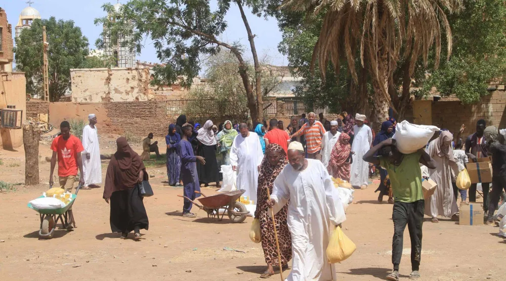 Residents receive aid from World Food Program (WFP) at Al-Omada neighborhood of Omdurman, the twin city of Khartoum on March 11, 2026. (AFP)