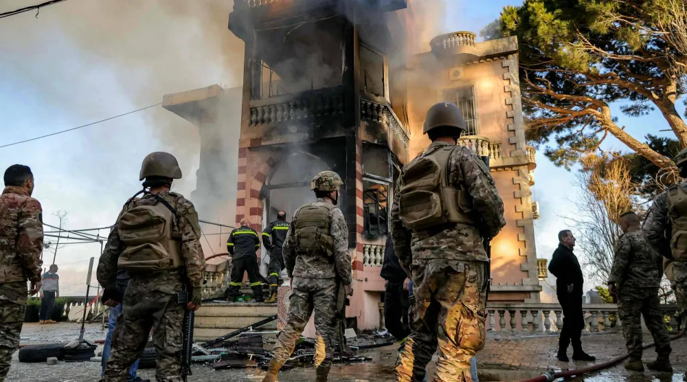 جنود لبنانيون وعناصر من الدفاع المدني يتفقدون مبنى احترق إثر قصف إسرائيلي على قرية مرجعيون جنوب لبنان (أ.ف.ب)