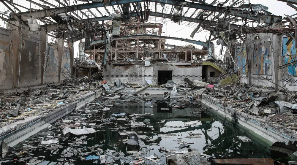 مجمع رياضي في طهران دمر في في الضربات الجوية أمس (د.ب.أ) ... وفي الإطار لاريجاني في آخر ظهور له خلال تجمع بالعاصمة الإيرانية الجمعة الماضي (رويترز)