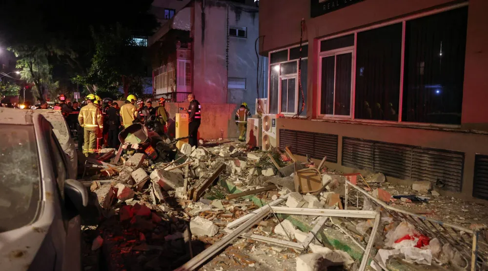 رجال إنقاذ يتفقدون موقعاً تعرض لهجوم صاروخي إيراني وسط إسرائيل (رويترز)