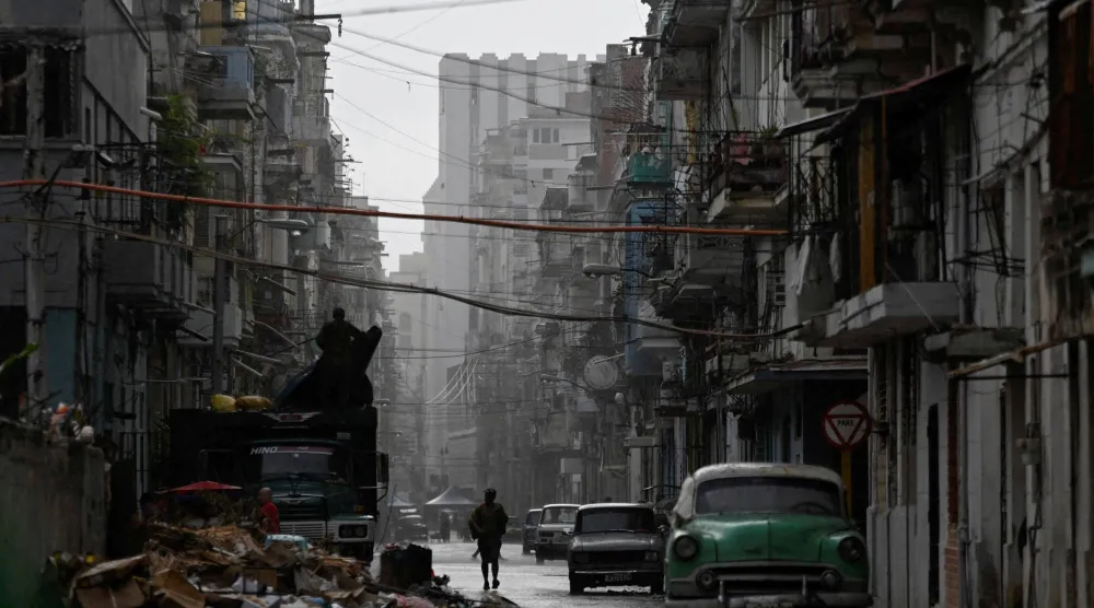 رجل يسير في أحد شوارع هافانا بعيد إعادة التيار الكهربائي للجزيرة (رويترز)