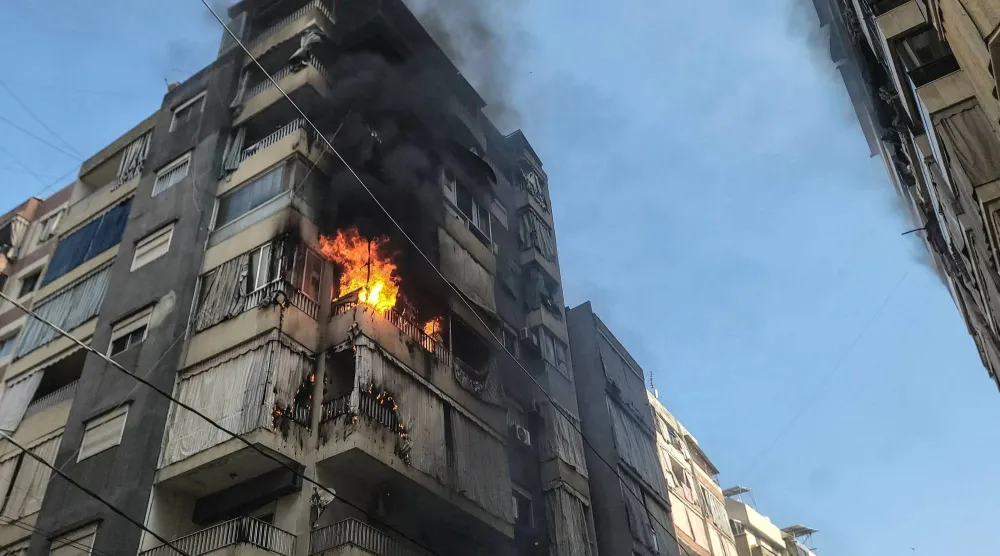 تتصاعد ألسنة اللهب من شقة استُهدفت بغارة جوية إسرائيلية في حي زقاق البلاط بوسط بيروت اليوم (أ.ف.ب)
