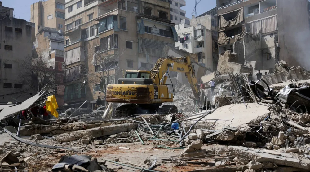 حفارة تزيل الأنقاض من موقع غارة إسرائيلية في حي زقاق البلاط بوسط بيروت في أعقاب تصعيد بين «حزب الله» وإسرائيل (رويترز)