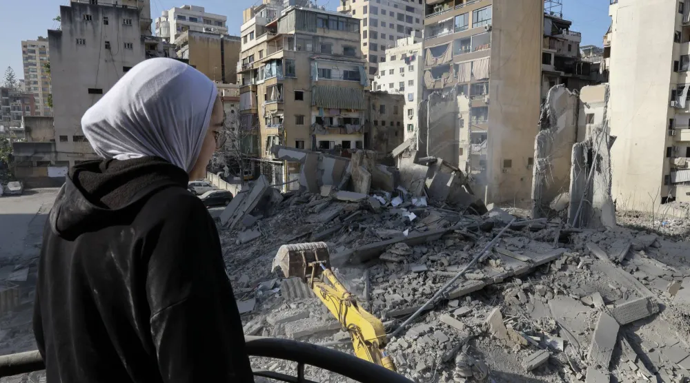 فتاة تنظر إلى موقع مبنى دمرته غارة إسرائيلية بالكامل في منطقة الباشورة في وسط بيروت (إ.ب.أ)