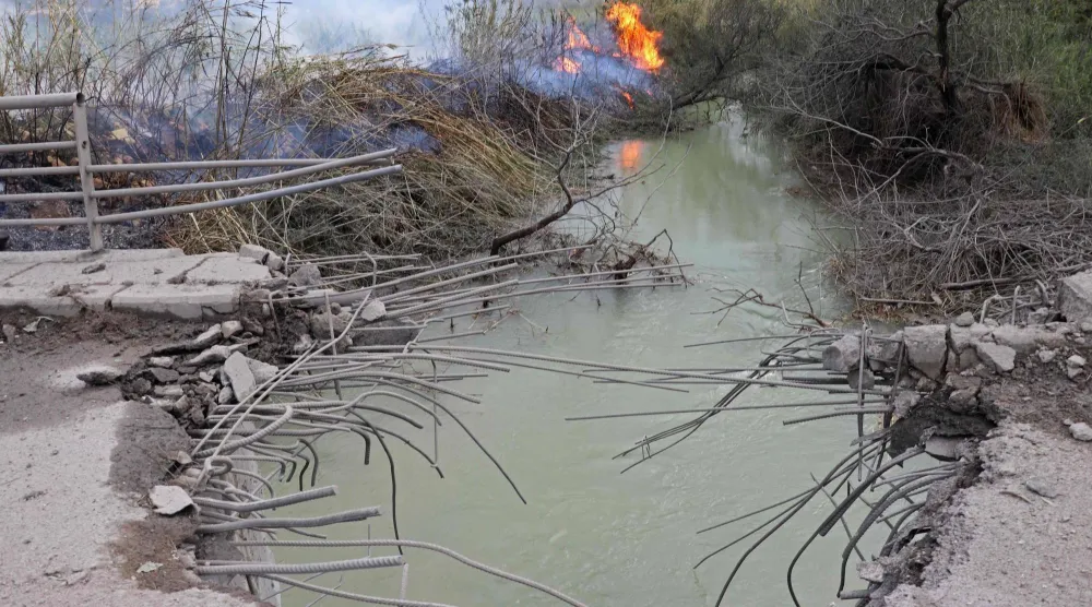 دمار ونيران في جسور القاسمية الساحلية على نهر الليطاني بجنوب لبنان (أ.ف.ب)