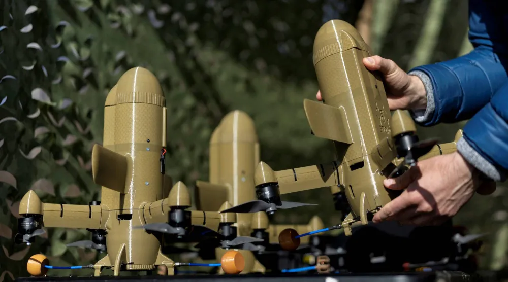 شخص يحمل طائرة اعتراضية من دون طيار في موقع غير معلن بأوكرانيا (رويترز)