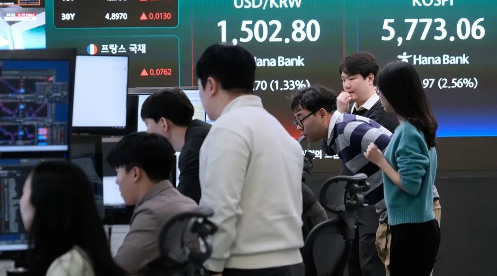 يراقب متداولو العملات شاشات بالقرب من شاشة تعرض مؤشر أسعار الأسهم الكوري المركب في سيول (أ.ب)