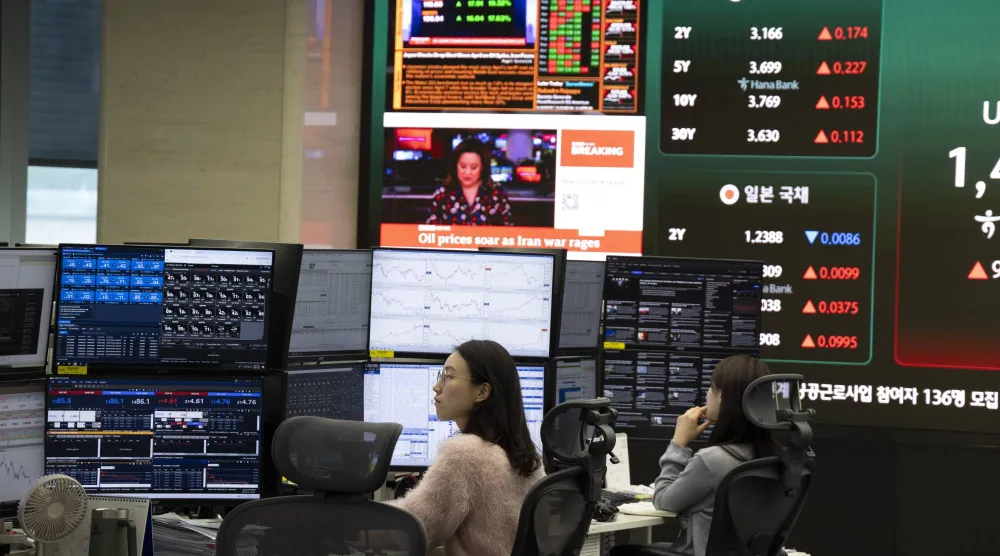متداولون كوريون جنوبيون يعملون أمام شاشات تعرض مؤشرات الأسهم ببنك «هانا» في سيول (إ.ب.أ)