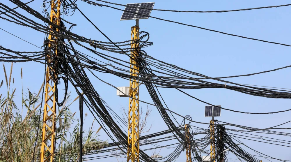 كابلات كهربائية متصلة بأعمدة كهرباء في بيروت يوم 18 فبراير 2022 (رويترز)