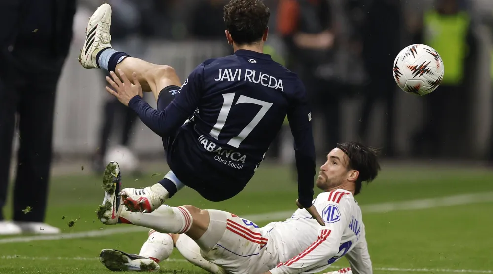 رويدا لاعب سيلتا فيغو يتعرض لدخول خشن من لاعب ليون نيكولا (إ.ب.أ)