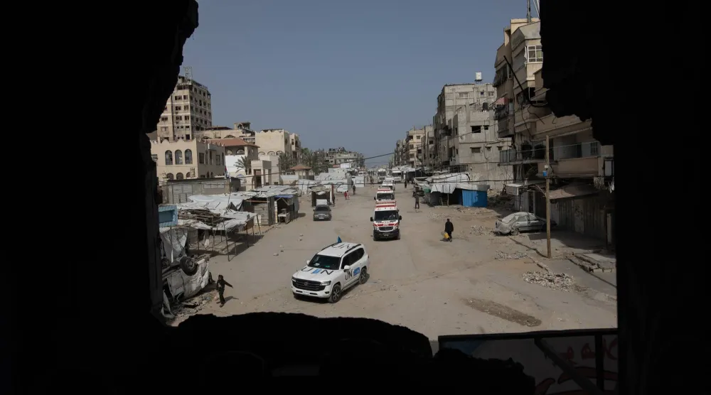 سيارات تحمل أول مجموعة من الجرحى يغادرون مقر الصليب الأحمر الفلسطيني في خان يونس متجهين إلى معبر رفح الحدودي مع مصر (إ.ب.أ)