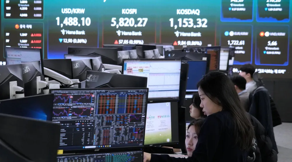 متداولو العملات يراقبون شاشات بالقرب من شاشة تعرض مؤشر أسعار الأسهم الكوري المركب «كوسبي» (أ.ب)