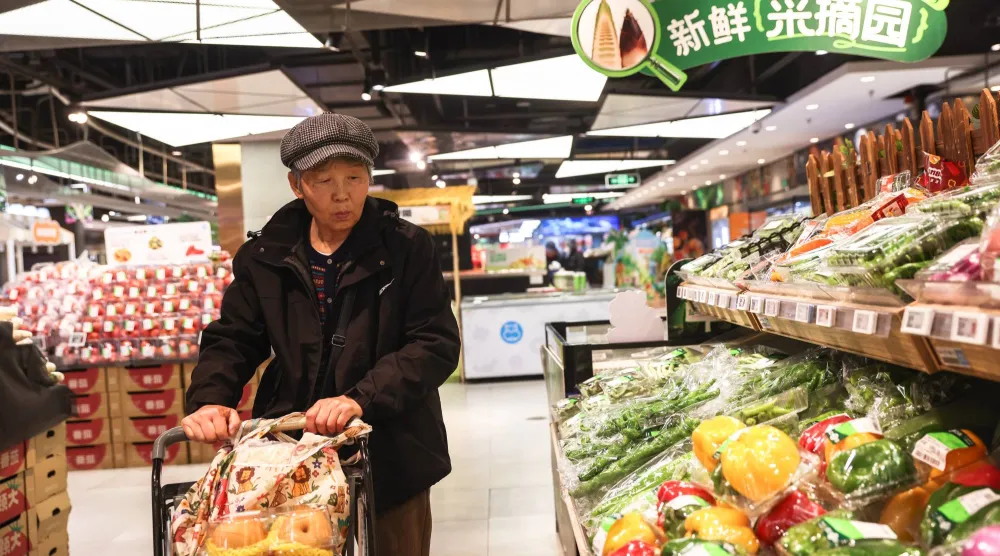 امرأة مسنة تتسوق داخل متجر في بكين (إ.ب.أ)