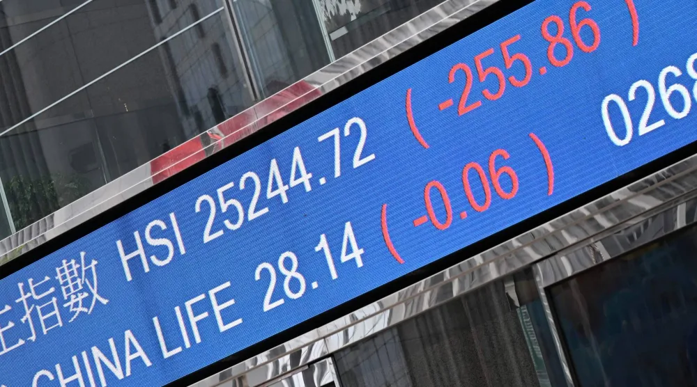 شاشة تعرض حركة الأسهم على مقر البورصة في جزيرة هونغ كونغ الصينية (أ.ف.ب)