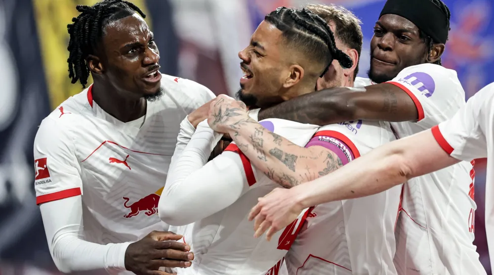 لاعب لايبزغ نيامين هنريكس يحتفل بتسجيل الهدف الخامس لفريقه خلال مواجهة هوفنهايم (إ.ب.أ) 