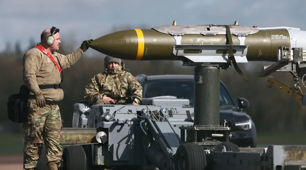 أفراد من الجيش الأمريكي يُزيلون ذخائر الهجوم المباشر المشترك (JDAM) من قاذفة قنابل من طراز B-1 لانسر تابعة لسلاح الجو الأمريكي في قاعدة فيرفورد الجوية التابعة لسلاح الجو الملكي البريطاني (أ.ف.ب)