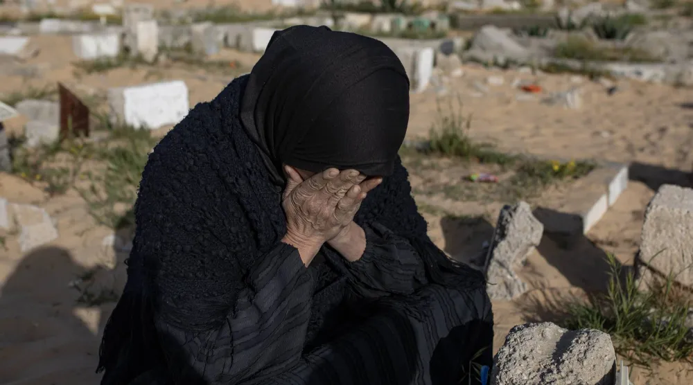 فلسطينية تبكي لدى زيارة قبور أقاربها في خان يونس جنوب قطاع غزة... الجمعة (إ.ب.أ)