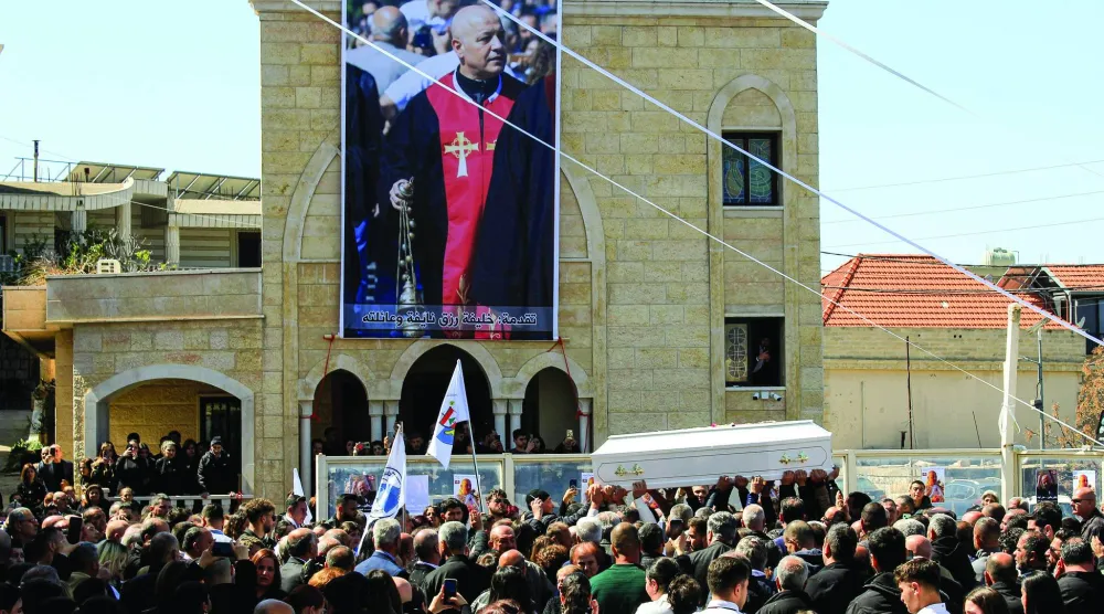 مسيحيون من بلدات مسيحية في جنوب لبنان يحملون نعش الأب بيار الراعي الذي قتل بنيران إسرائيلية في بلدته القليعة بجنوب لبنان (د.ب.أ)
