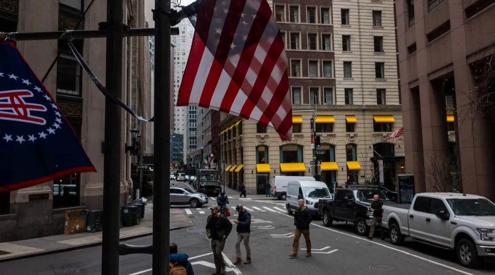 الناس يسيرون في الحي المالي مقر بورصة نيويورك (أ.ف.ب)