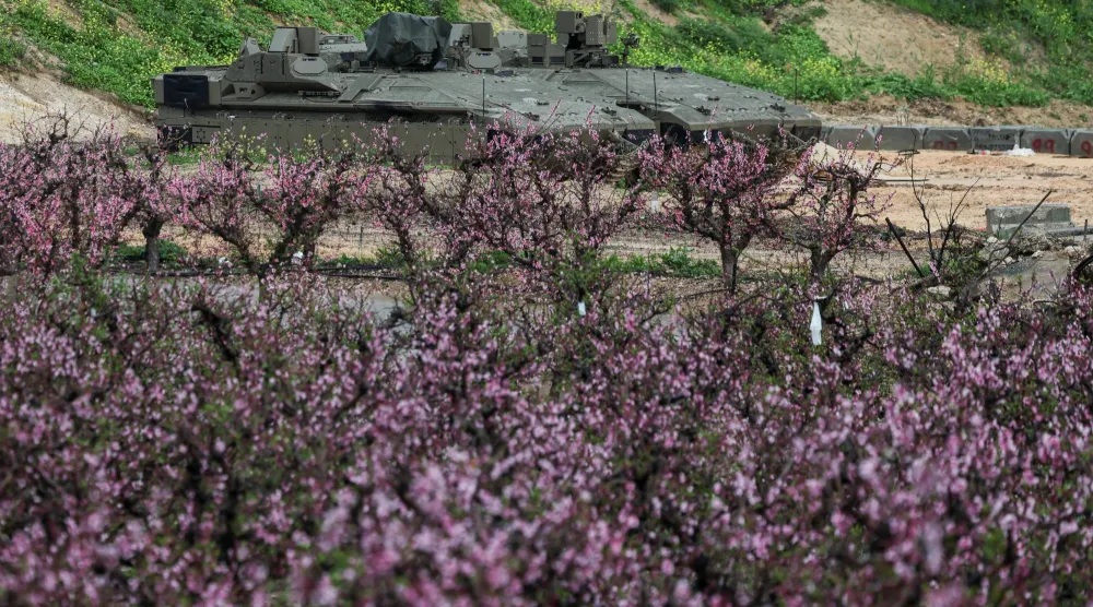 مركبات عسكرية إسرائيلية متوقفة على الجانب الإسرائيلي من الحدود مع لبنان (رويترز)