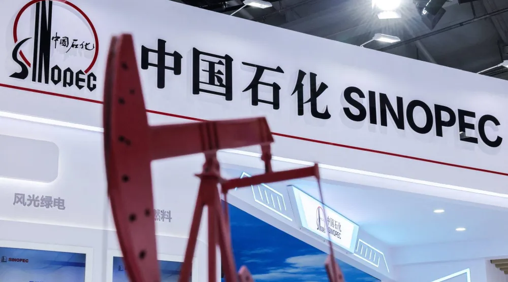 نموذج رافعة مضخة نفط بجوار شعار شركة التكرير الصينية العملاقة «سينوبك» (رويترز)