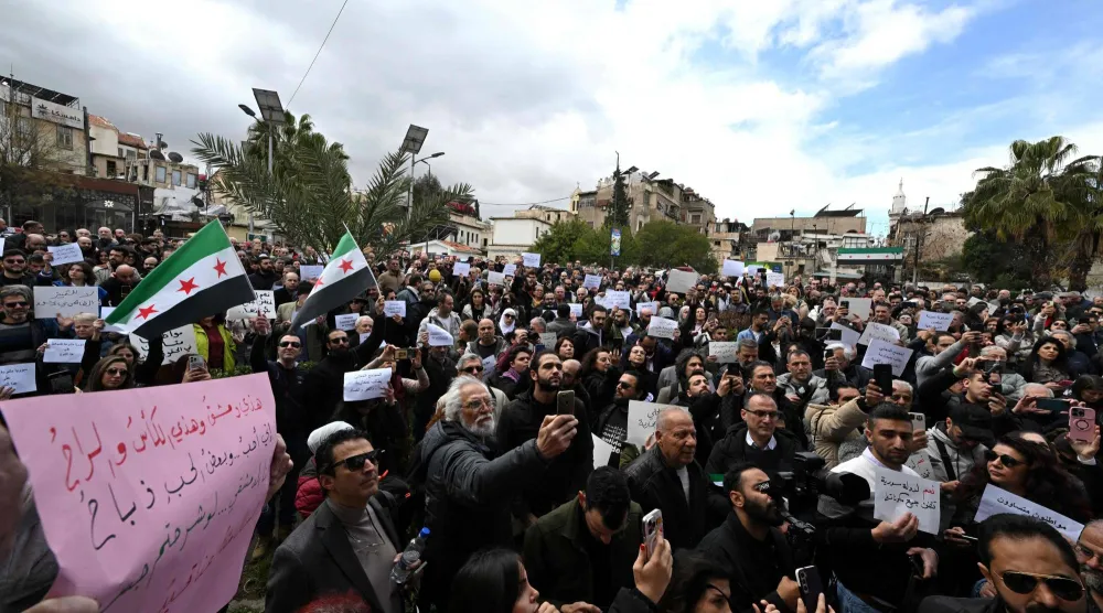 سوريون ينفذون اعتصاماً صامتاً احتجاجاً على قرار السلطات تقييد بيع المشروبات الكحولية في حي باب توما بدمشق اليوم (أ.ف.ب)