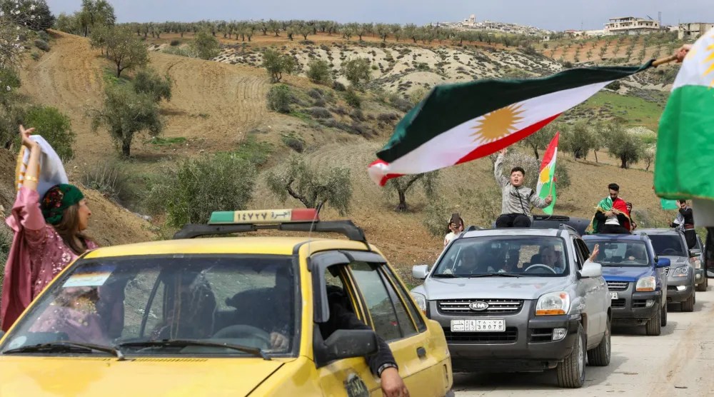 رفع الأكراد السوريون أعلام كردستان خلال احتفالات عيد النوروز في عفرين بريف حلب السبت (رويترز)