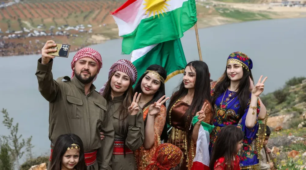 Suriye’nin kuzeyindeki Halep kırsalında bulunan Afrin’de cumartesi günü Nevruz Bayramı’nı kutlayan Suriyeli Kürtler hatıra fotoğrafı çekiyor. (Reuters)