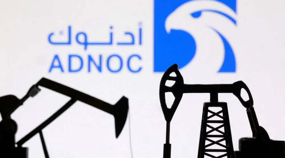 رافعات مضخات نفط مطبوعة بتقنية الطباعة ثلاثية الأبعاد بالإضافة إلى شعار شركة بترول أبوظبي الوطنية «أدنوك» (رويترز)