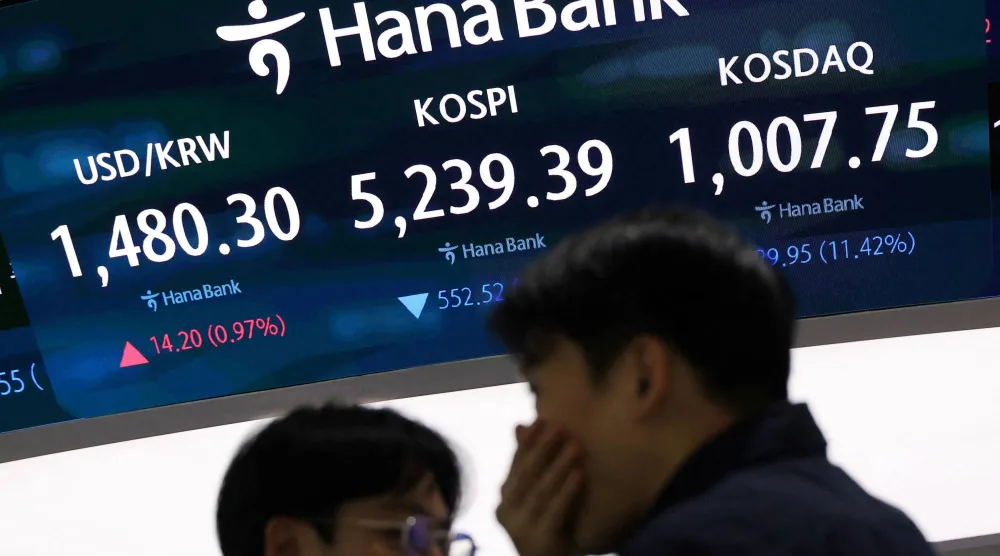 متداولون أمام شاشة تعرض مؤشر «كوسبي» وسعر الدولار داخل غرفة التداول بأحد البنوك في سيول (رويترز)