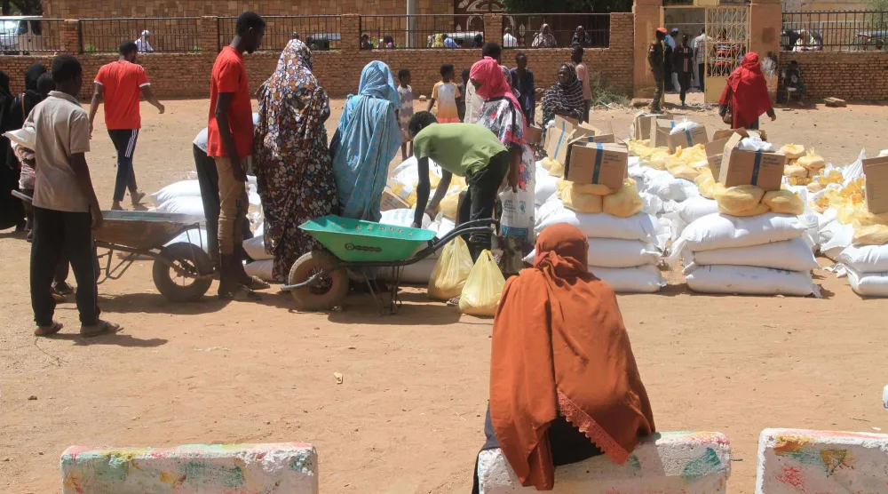 توزيع مساعدات غذائية من برنامج الغذاء العالمي في ضواحي أم درمان بالخرطوم يوم 11 مارس الحالي (أ.ف.ب)