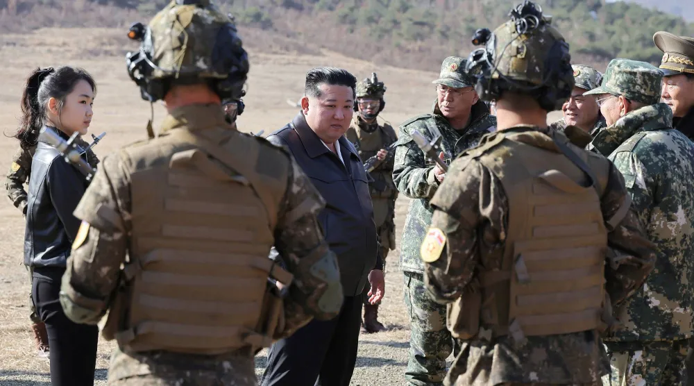 الزعيم الكوري الشمالي كيم جونغ أون وابنته وسط مجموعة من الجنود خلال تدريب تكتيكي في بيونغ يانغ (رويترز)