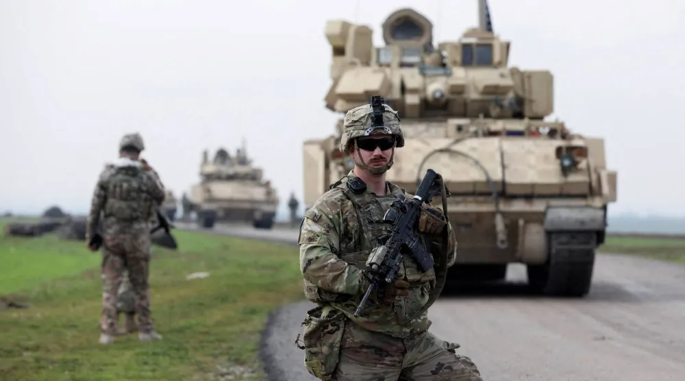 جندي من التحالف الذي تقوده الولايات المتحدة يقف حارساً خلال دورية مشتركة بين الولايات المتحدة و«قوات سوريا الديمقراطية» (قسد) بقيادة الأكراد في ريف القامشلي شمال شرقي سوريا... 8 فبراير 2024 (رويترز)