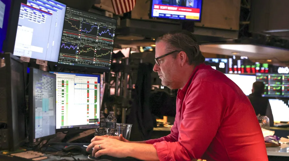 متداول يراقب شاشات تعرض مؤشرات الأسهم في بورصة نيويورك (إ.ب.أ)