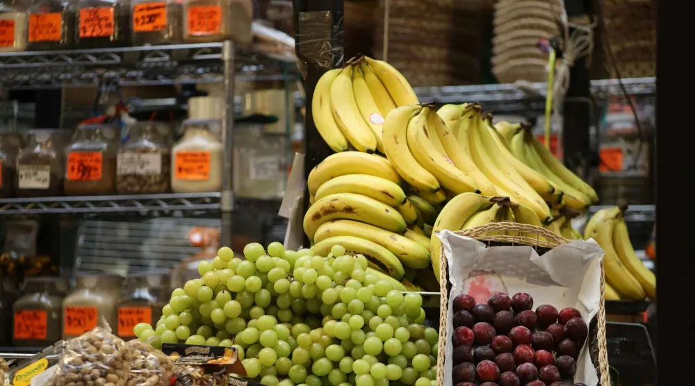 كمية من الموز والعنب معروضة للبيع في أحد المتاجر (بيكسلز)