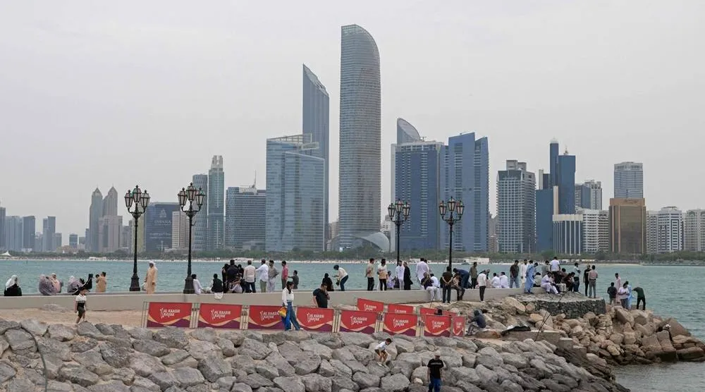  People sit along the corniche area on the occasion of Eid al-Fitr, marking the end of the holy month of Ramadan, in Abu Dhabi on March 20, 2026. (AFP) 