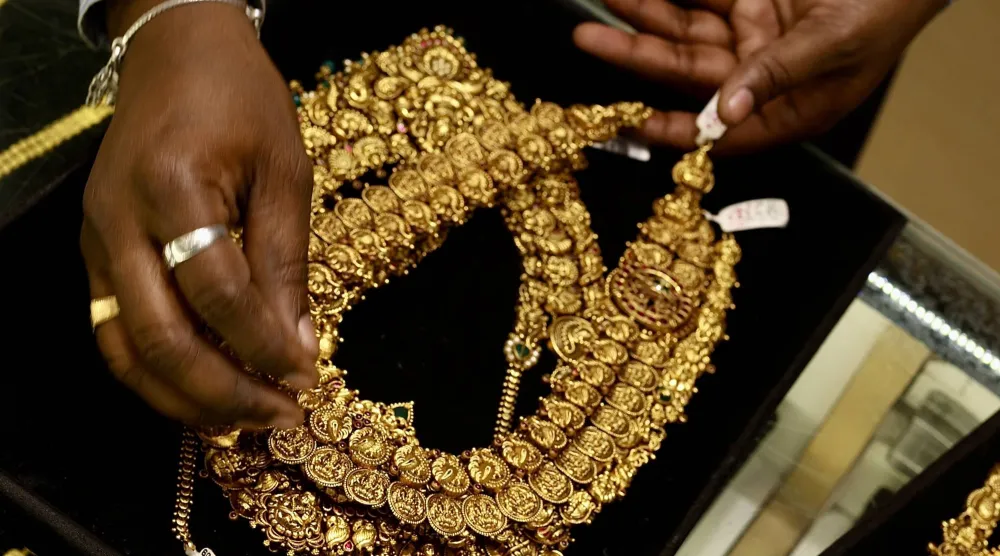 امرأة هندية تعرض قطعة مجوهرات ذهبية في متجر مجوهرات في بنغالور (إ.ب.أ)