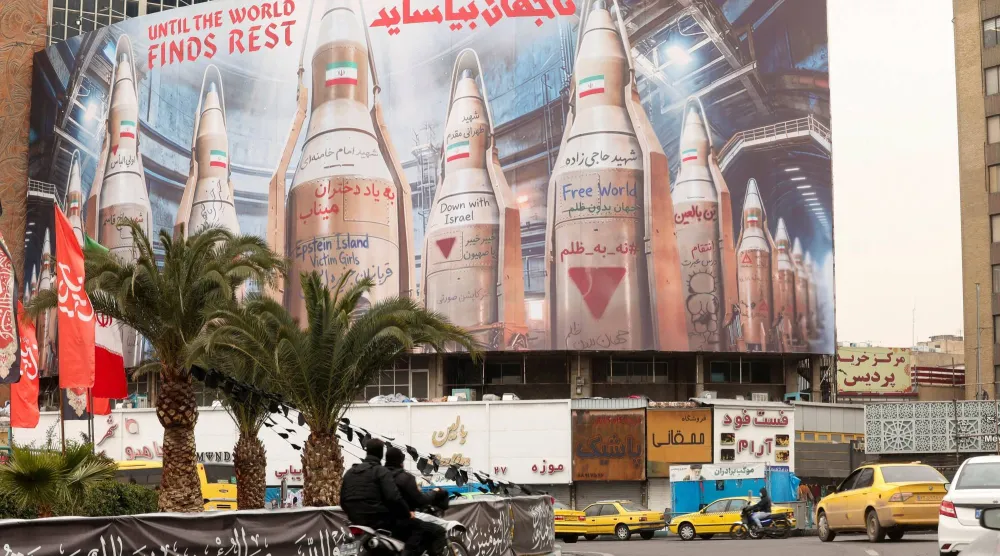 لوحة دعائية ضخمة عليها صور لصواريخ إيرانية في طهران (رويترز)