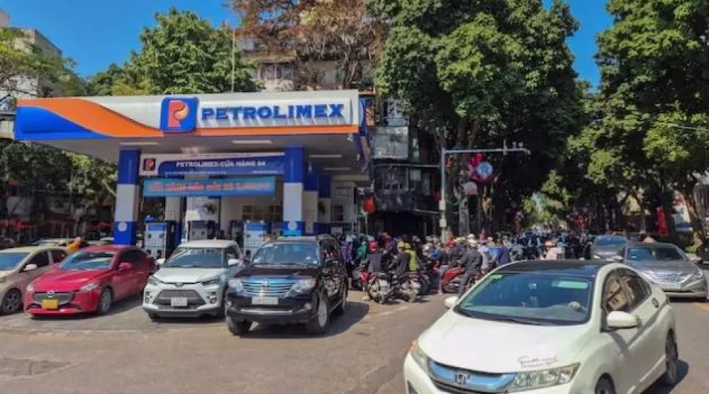 أشخاص يصطفون لشراء البنزين في محطة وقود في هانوي (رويترز)