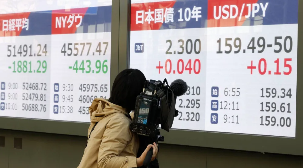 مصور تلفزيوني يصوّر لوحات مؤشرات تُظهر عائد سندات الحكومة اليابانية لأجل 10 سنوات في طوكيو (إ.ب.أ)