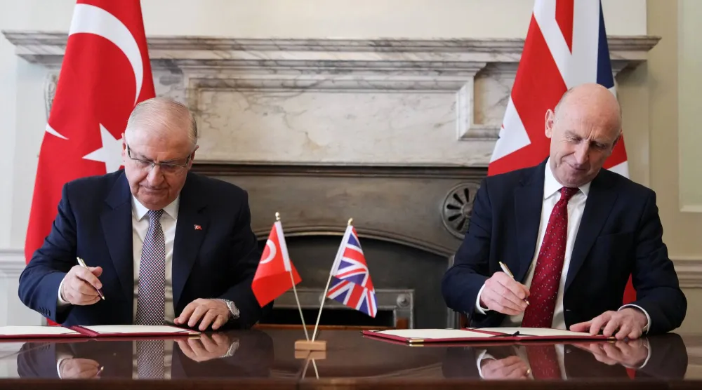 وزير الدفاع البريطاني جون هيلي ونظيره التركي يشار غولر يتصافحان بعد توقيع اتفاقية تسمح لتركيا بشراء 20 طائرة من طراز «يوروفايتر تايفون»... لندن - 25 مارس 2026 (رويترز)