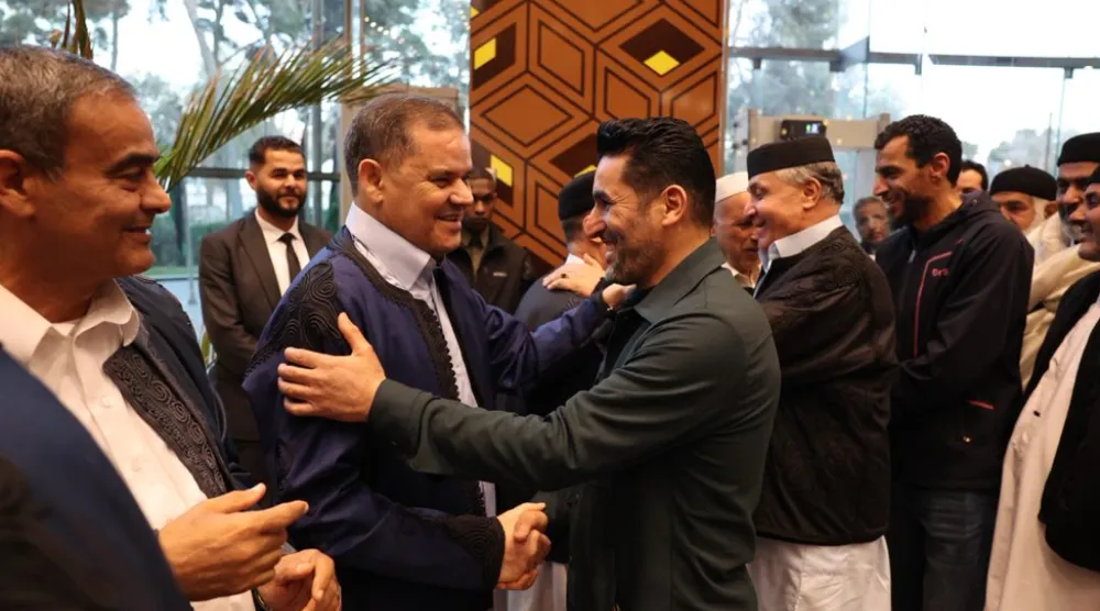 رئيس حكومة الوحدة عبد الحميد الدبيبة يصافح قائد ميليشيا «دعم الاستقرار» قبل مأدبة إفطار في الزاوية (مكتب الدبيبة)