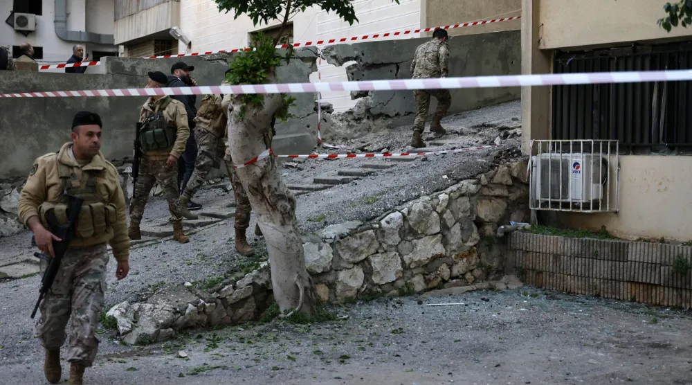 جنود من الجيش اللبناني يقفون في الموقع الذي سقطت فيه شظايا صاروخ تم اعتراضه بمنطقة حارة صخر بقضاء كسروان شمال بيروت 24 مارس 2026 (إ.ب.أ)