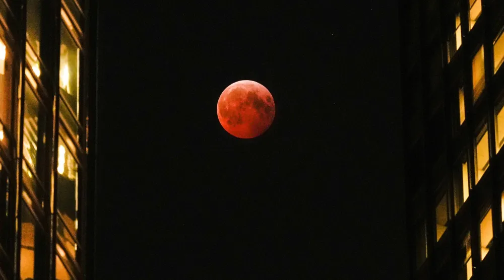 ظِلّ الأرض يرسم على القمر دائرةً من نارٍ خافتة (أ.ب)