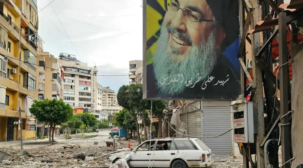 Beyrut'un güney banliyösünde enkazın arasında çekilmiş eski Hizbullah Genel Sekreteri Hasan Nasrallah'ın posteri (AFP)