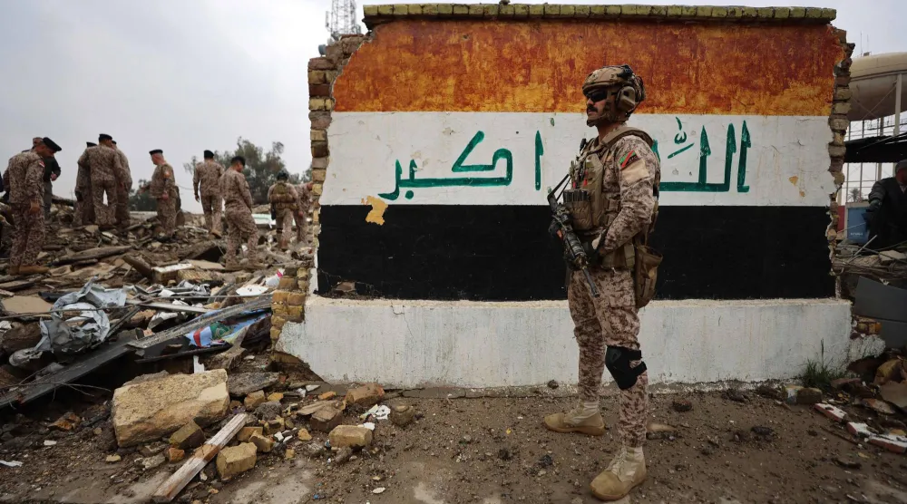 جنود عراقيون يتفقدون موقع مركز رعاية صحية مُدمَّر في قاعدة الحبانية العسكرية التي استُهدفت بغارة جوية أسفرت عن مقتل 7 من أفراد الأمن وإصابة 13 آخرين غرب بغداد (أ.ف.ب)