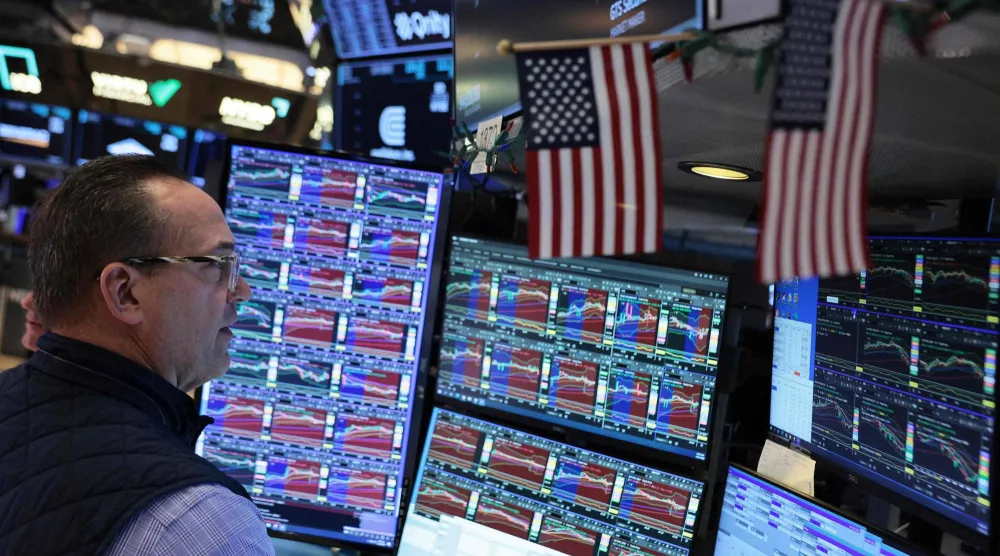 متداول يراقب شاشات تعرض مؤشرات الأسهم في بورصة نيويورك (أ.ف.ب)